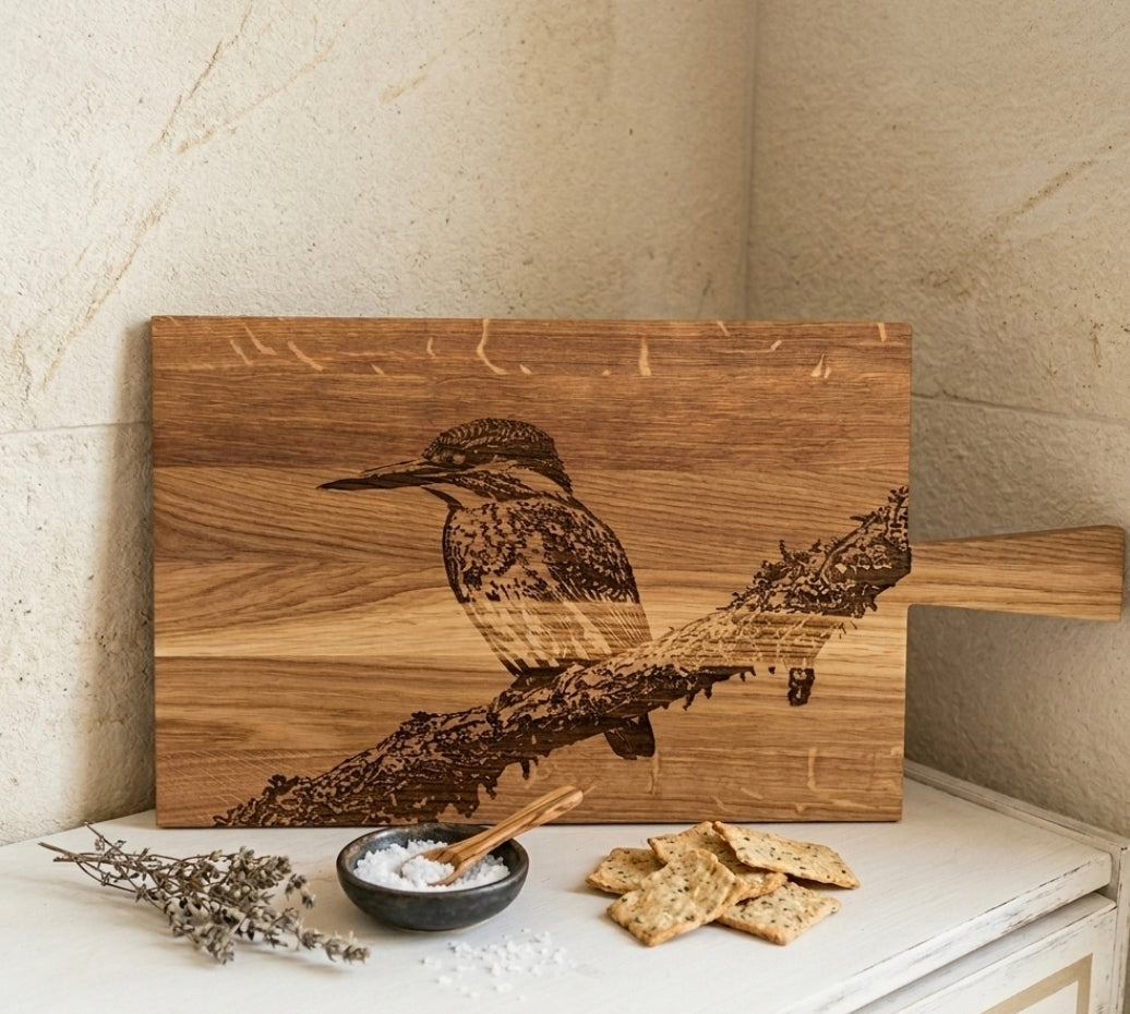 Hochwertiges Holzbrett aus Eiche mit kunstvoller Lasergravur eines Eisvogels auf einem Ast, markante Maserung, perfekt als dekoratives Servierbrett oder Geschenk.
