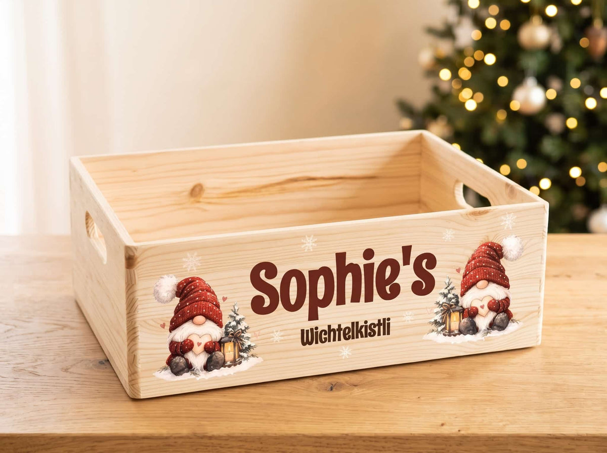 Personalisierte Wichtelkiste aus hellem Holz mit der Aufschrift «Sophie's Wichtelkistli» und zwei Wichteln mit roten Mützen